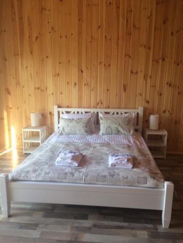 a bedroom with a large bed with wooden walls at Relax villa Poduzska in Sinyak