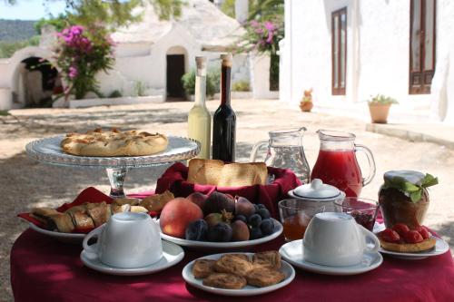 奇斯泰尼諾的住宿－Masseria Gianecchia，餐桌上摆放着食物和葡萄酒