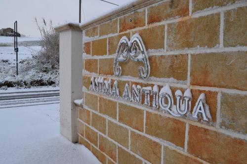a brick wall with a sign on it in the snow at Anima Antiqua Relais & Spa in Gioia Sannitica