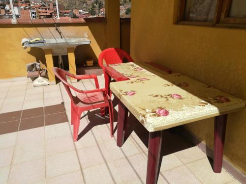 a table and chairs in a room with a window at Homestay Jorge, Sucre in Sucre