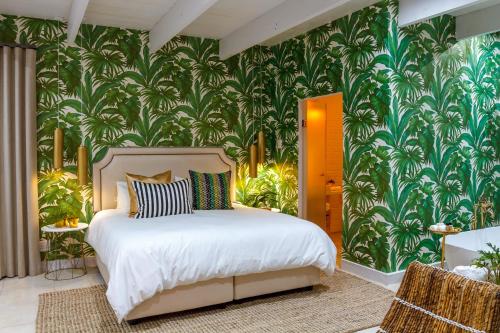 a bedroom with a bed with a tropical wallpaper at Bly B&B in Pretoria