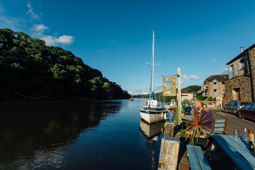 a boat is docked at a dock in a river at The Maltsters Arms in Totnes