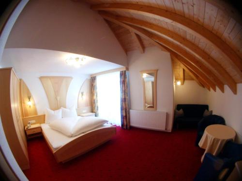 a hotel room with a bed and a large window at Hotel Garni Pradella in Ischgl