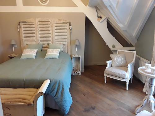 1 dormitorio con 1 cama grande y 1 silla en Au Moulin de Valérie, en Frencq