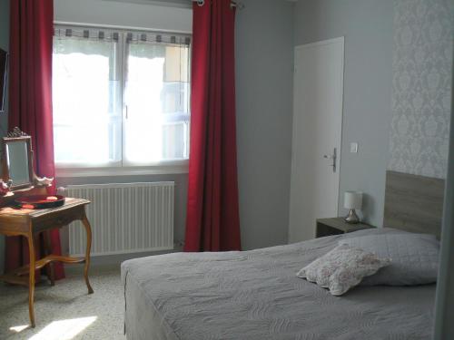 une chambre avec un lit, un bureau et une fenêtre dans l'établissement L'Oustau de MaLo, à Sainte-Cécile-les-Vignes