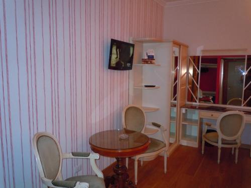a room with a table and chairs and a desk at Hotel Metropole Suisse in Como