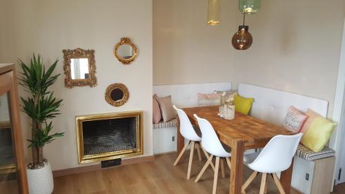 een eetkamer met een tafel en stoelen en een open haard bij Apartament Marina Port Cambrils in Cambrils
