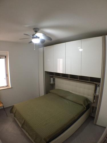 a bedroom with a bed and white cabinets at La casa del Tramonto in Praia a Mare