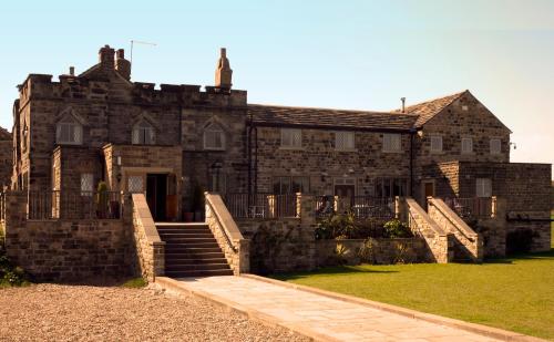 an old stone house with stairs in front of it at Norfolk Arms Hotel, Ringinglow in Sheffield