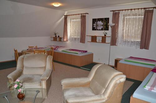 a living room with two chairs and two beds at Penzion Pod Vápenkami in Strážnice