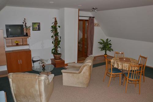 a living room with a couch and a table and chairs at Penzion Pod Vápenkami in Strážnice