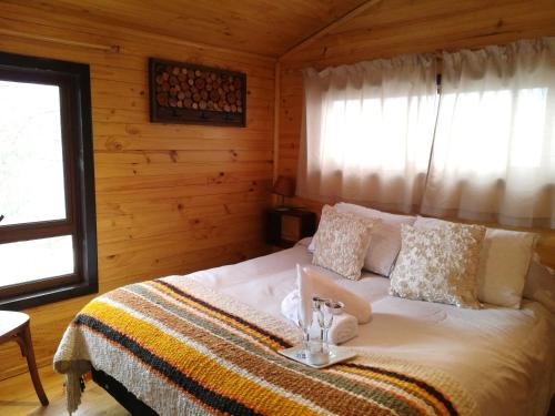 a bedroom with a bed in a log cabin at Estación Benedicto in Manzanar