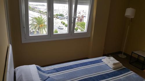 een bed in een kamer met een raam bij Apartament Marina Port Cambrils in Cambrils