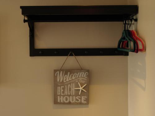 a welcome to the beach house sign on a wall at Argyle Lodge in Rush