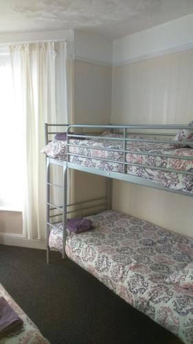 a bedroom with two bunk beds and a window at Smugglers Rest in Newquay