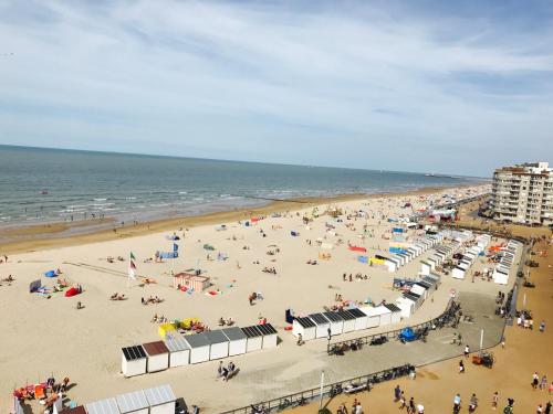 una spiaggia con molta gente e l'oceano di Apartment S7 a Ostenda