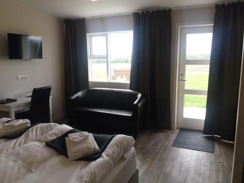 a hotel room with a bed and a chair and a window at Hotel Vos in Hella