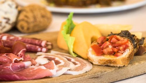 a cutting board with different types of food on it at Hotel Da Vinci in Montecatini Terme