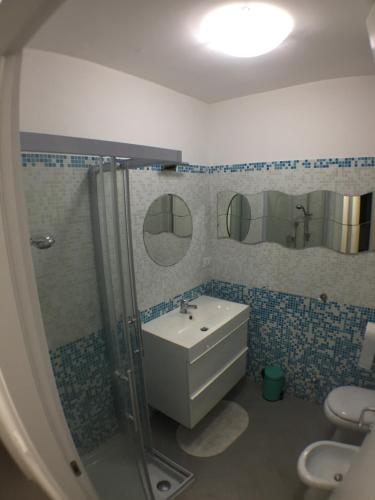 a bathroom with a sink and a shower and a toilet at La casa del Tramonto in Praia a Mare