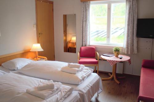 Habitación de hotel con cama, silla y ventana en Torsetlia en Dagali