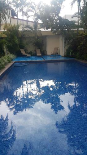 a large swimming pool with blue tiles on it at Hotel Portal Colonial in San José