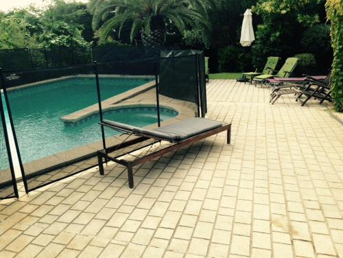 un banc installé à côté d'une piscine dans l'établissement Villa Ecluses Mediterranee, à Portiragnes