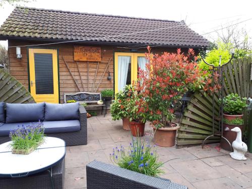 a patio with a blue couch and some plants at It tunhuske in Renkum
