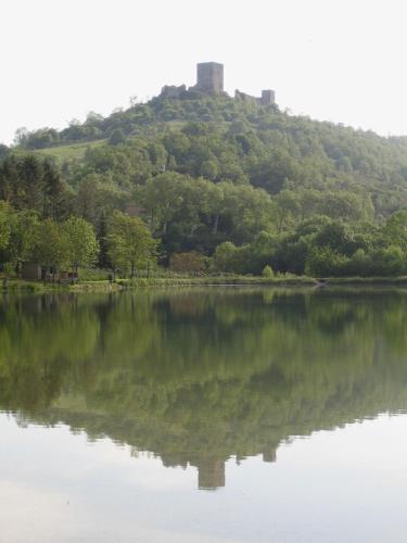 a view of a hill with a reflection in a lake at Hôtel De France in Chalabre