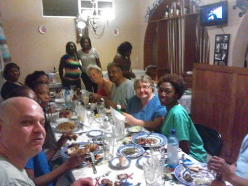 a group of people sitting at a table eating food at La Belle Maison Milot in Samson