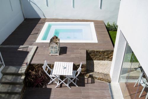 una terrazza con tavolo, sedie e piscina di Art 4 You Cascais Suites a Cascais