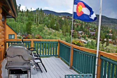 a patio with a flag and a grill on a deck at Gateway Inn in Grand Lake