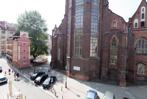 a large brick building with cars parked in front of it at 2/3 APARTMENTS Old Town in Wrocław