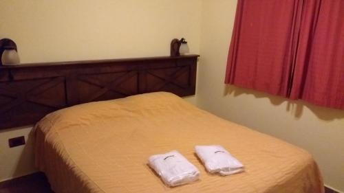 a bedroom with a bed with two towels on it at Complejo La Colina in Federación