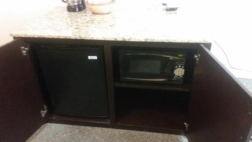 a microwave in a cabinet with a counter top at The Gold Lodge in Sonora