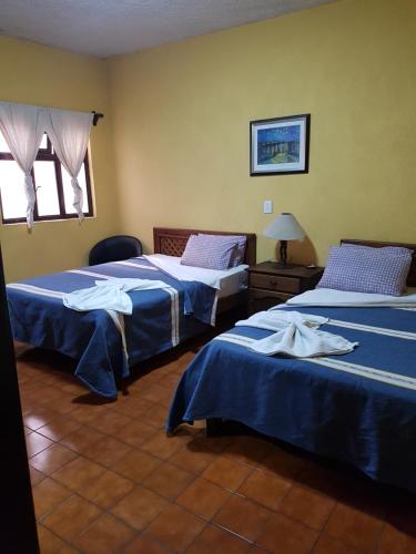 A bed or beds in a room at Hotel Nuevo Cupatitzio