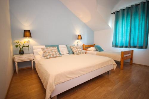 una camera con due letti e tende blu di Apartmani Kristijan a Jesenice