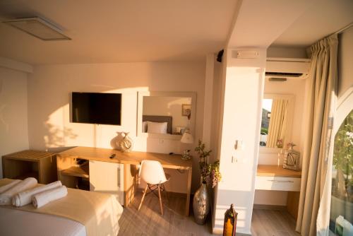 a bedroom with a bed and a desk with a computer at Kratiras View Luxury Suites in Fira