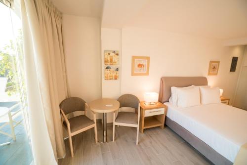 a bedroom with a bed and a table and chairs at Kratiras View Luxury Suites in Fira