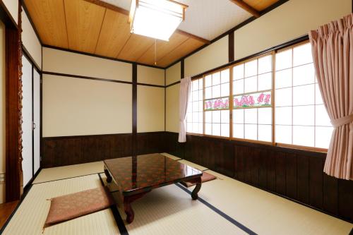 a room with a table in a room with windows at Tsuyukusa in Takayama