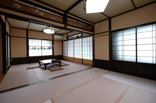 a room with a table in a room with windows at Tsuyukusa in Takayama