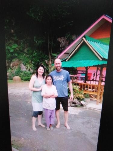 a family posing for a picture in front of a building at Khao Chang View Resort in Phangnga
