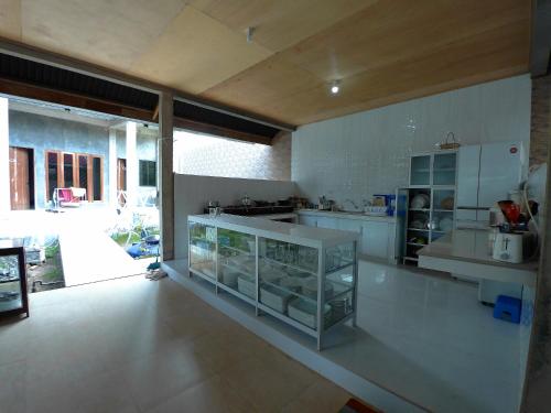 a kitchen with white counters and a large window at Eddie's Homestay in Lhonga