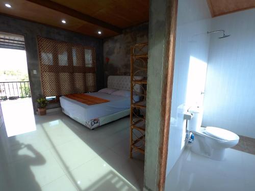 um quarto com uma cama e um WC. em Eddie's Homestay em Lhonga