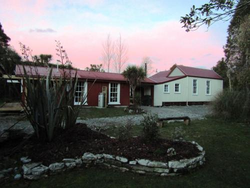 a house with a red and white house at Greenstone Retreat in Kumara