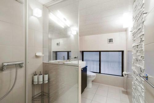 a bathroom with a toilet and a sink and a shower at White Horse Hotel in Hakuba