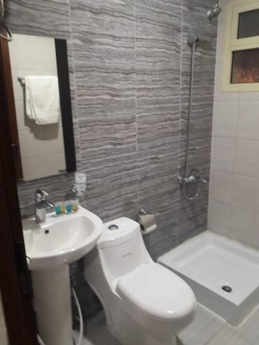 a bathroom with a toilet and a sink and a shower at تاج الخليج للشقق المخدومة in Dammam