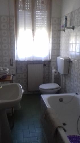 リド・ディ・カマイオーレにあるCasa Ludovicaのバスルーム(トイレ2つ、バスタブ付)、窓が備わります。