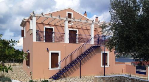 a house with a staircase in front of it at Vila Tselentata in Fiskardho