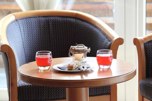 a small table with a plate of food and two glasses at Hotel Fanes Suite & Spa in Moena