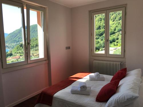 ベッラージョにあるCasa Oleandroのベッドルーム1室(窓2つ、赤い枕付きのベッド1台付)